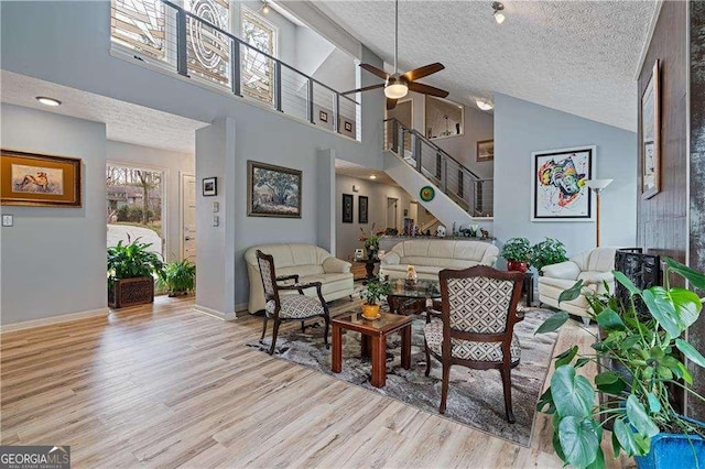 2590 Runic Way, Johns Creek, GA 30022 - living room with a textured ceiling, high vaulted ceiling, light wood-style flooring, a ceiling fan, and stairway