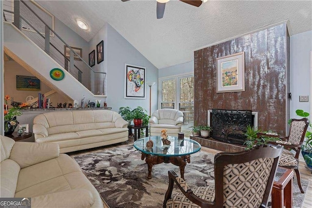 2590 Runic Way, Johns Creek, GA 30022 - living area featuring a ceiling fan, a textured ceiling, a fireplace with raised hearth, and high vaulted ceiling