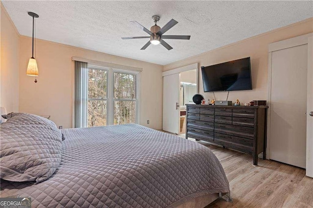 bedroom with a textured ceiling, ceiling fan, and wood finished floors