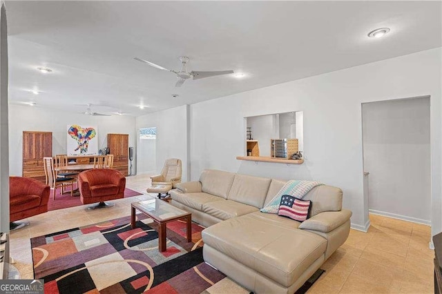 living room featuring light tile patterned floors, a ceiling fan, and baseboards