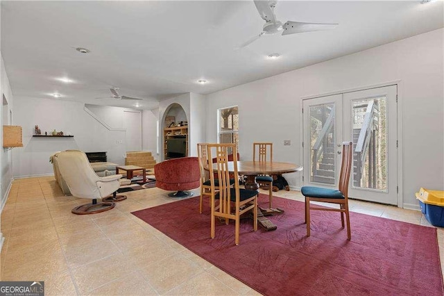 tiled dining space featuring arched walkways, french doors, recessed lighting, ceiling fan, and baseboards