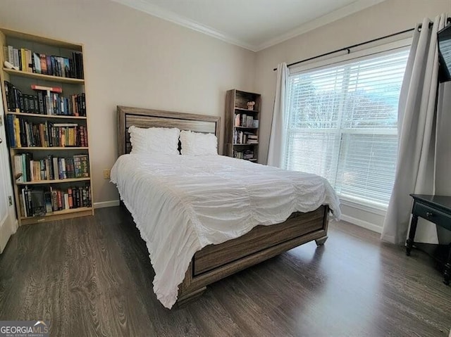 bedroom with crown molding, baseboards, and wood finished floors