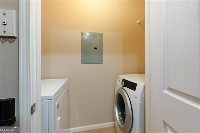 clothes washing area with laundry area, electric panel, washer and clothes dryer, and baseboards