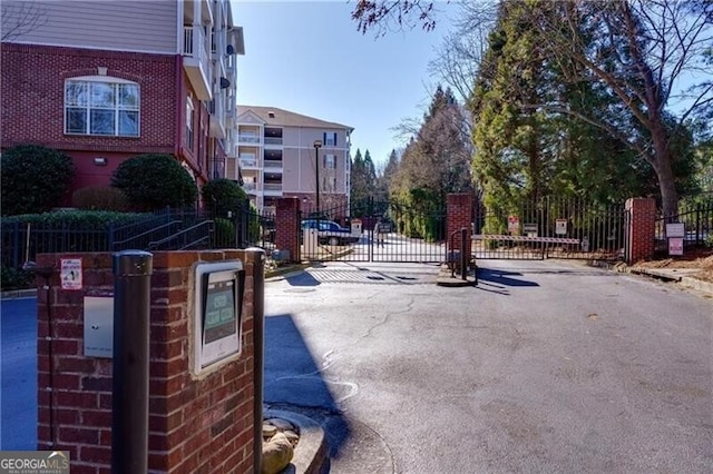 view of road with a gate, curbs, and a gated entry