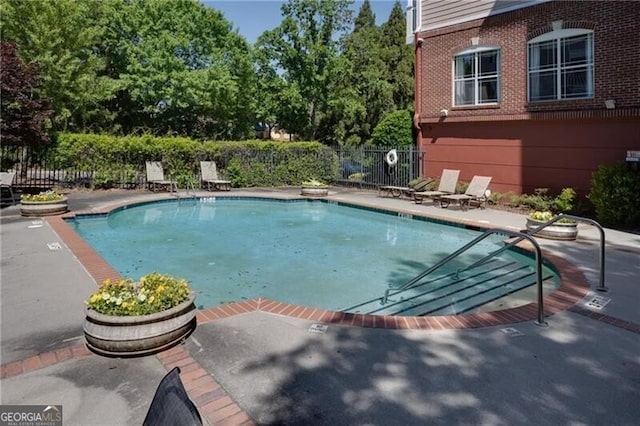 community pool featuring a patio area and fence