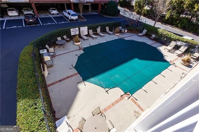 community pool with a patio and fence