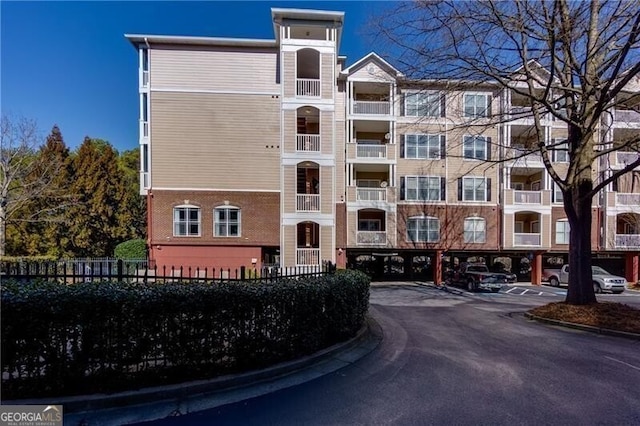 view of property with fence and parking