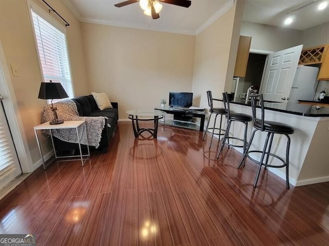 interior space featuring ornamental molding, baseboards, and wood finished floors