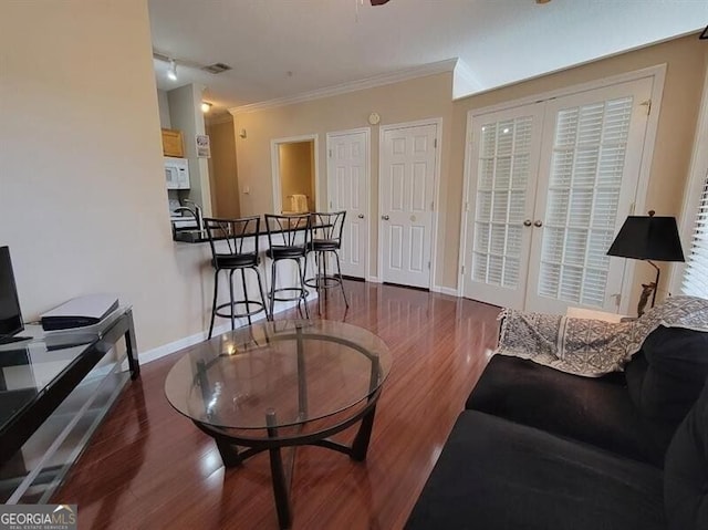 living area with french doors, visible vents, ornamental molding, wood finished floors, and baseboards