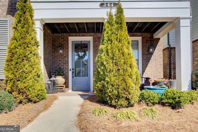 doorway to property with brick siding