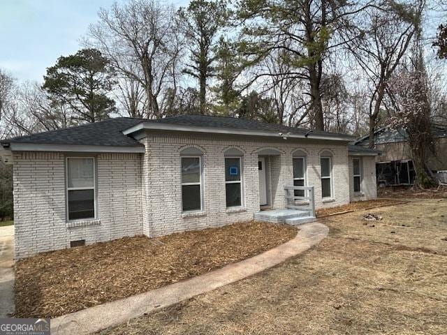 view of front of house featuring crawl space and brick siding