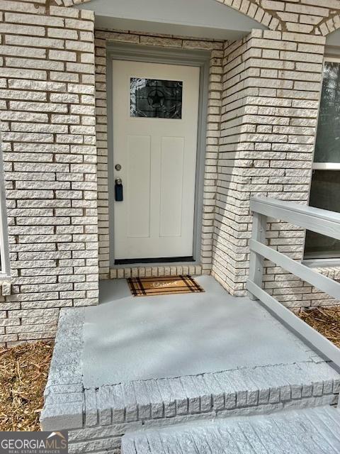 property entrance featuring brick siding