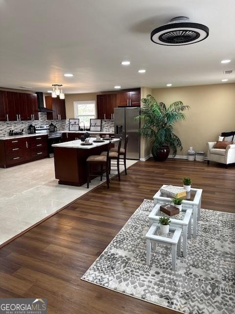 living area with light wood finished floors, visible vents, and recessed lighting