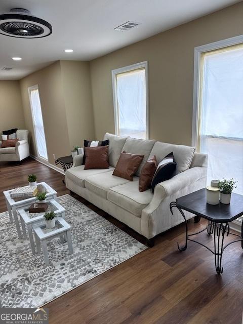 living area with recessed lighting, wood finished floors, and visible vents