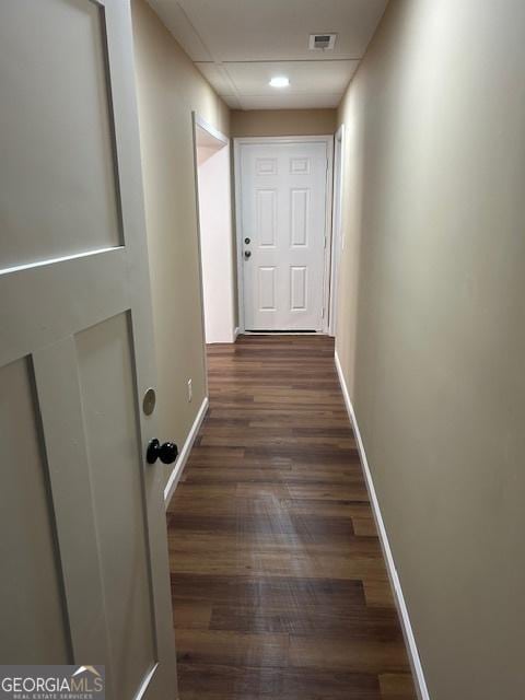 hallway with visible vents, baseboards, and dark wood finished floors