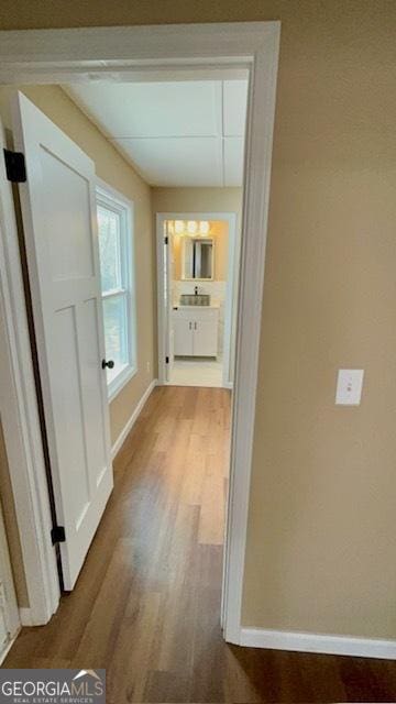 hallway featuring baseboards and wood finished floors