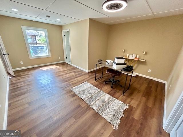 home office with wood finished floors, baseboards, and a paneled ceiling