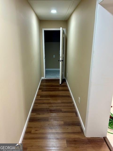 hall with baseboards and wood finished floors