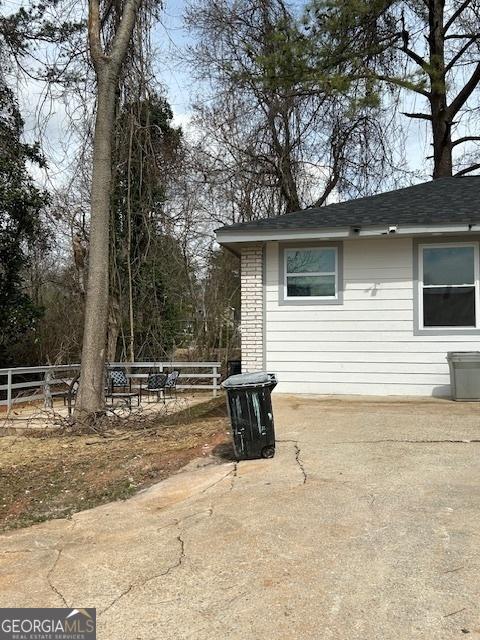 view of home's exterior with a patio area and fence