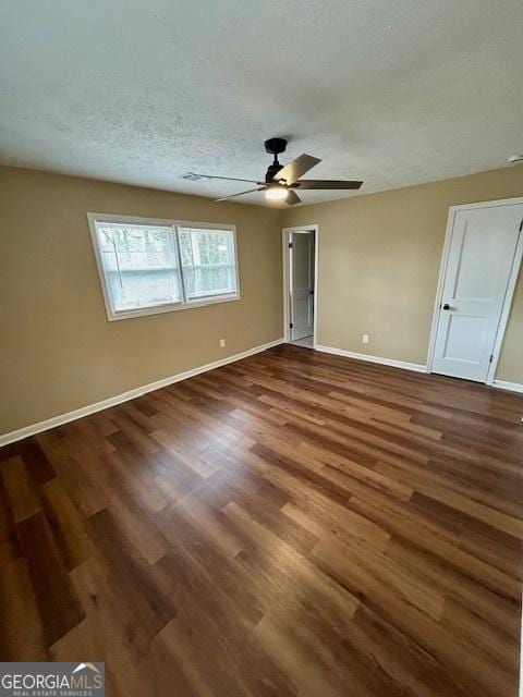 unfurnished bedroom with a ceiling fan, wood finished floors, baseboards, and a textured ceiling