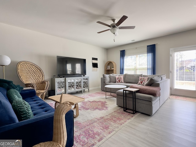 living room featuring ceiling fan, light wood finished floors, and visible vents