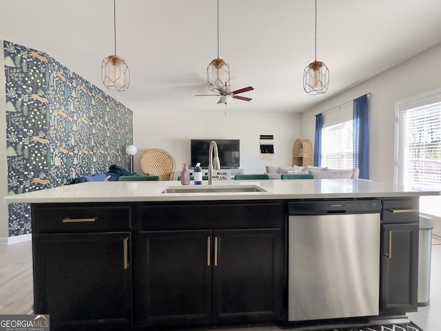 kitchen featuring light countertops, open floor plan, dark cabinetry, and stainless steel dishwasher