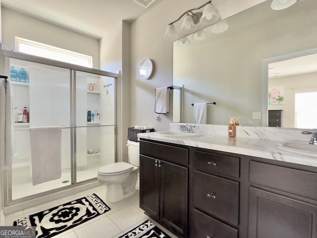 full bathroom featuring a stall shower, a sink, and tile patterned floors