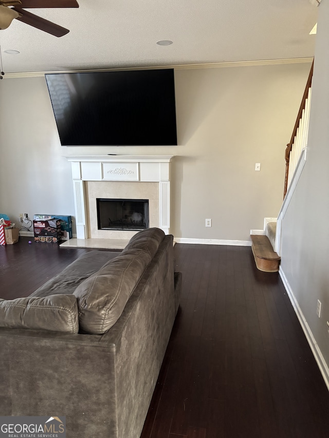 living room featuring ceiling fan, a high end fireplace, baseboards, stairs, and hardwood / wood-style floors