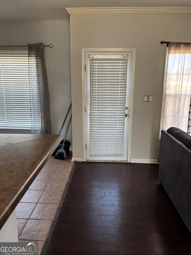 foyer with ornamental molding, wood-type flooring, and baseboards