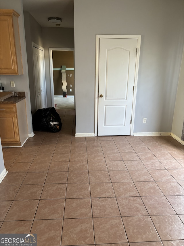 interior space with light tile patterned floors and baseboards