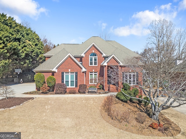 traditional-style house with roof with shingles and brick siding