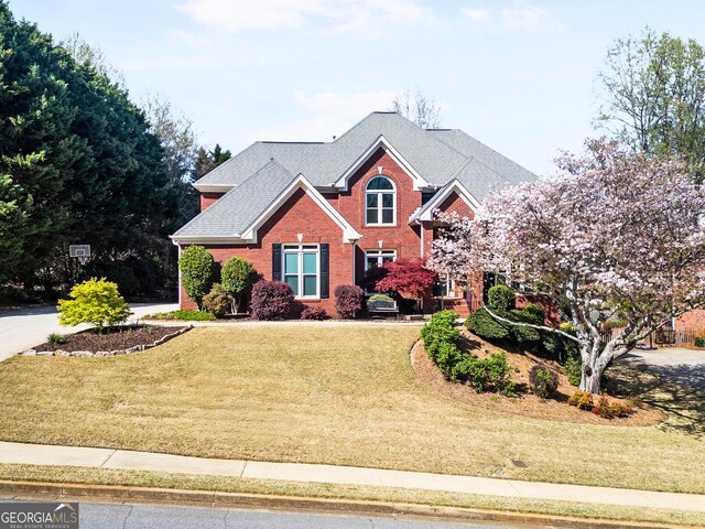 1574 Stepstone Way, Lawrenceville, GA 30043 - traditional home featuring brick siding, a front yard, and a shingled roof