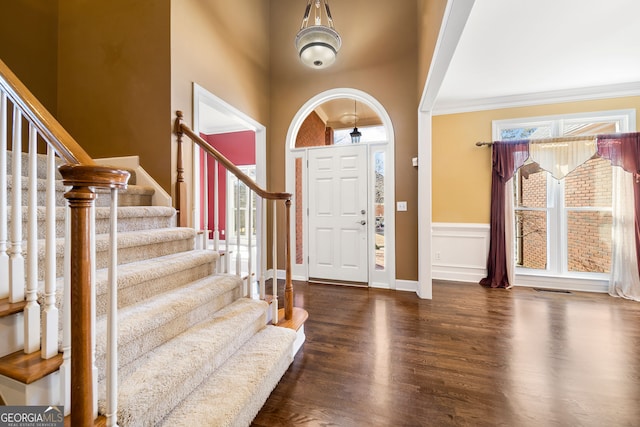 foyer entrance with visible vents, stairway, wood finished floors, and a wealth of natural light