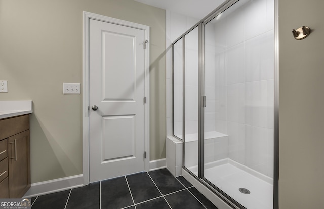 bathroom with tile patterned flooring, vanity, baseboards, and a shower stall