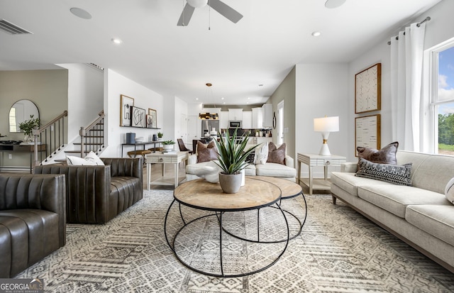 living room with a ceiling fan, recessed lighting, visible vents, and stairway