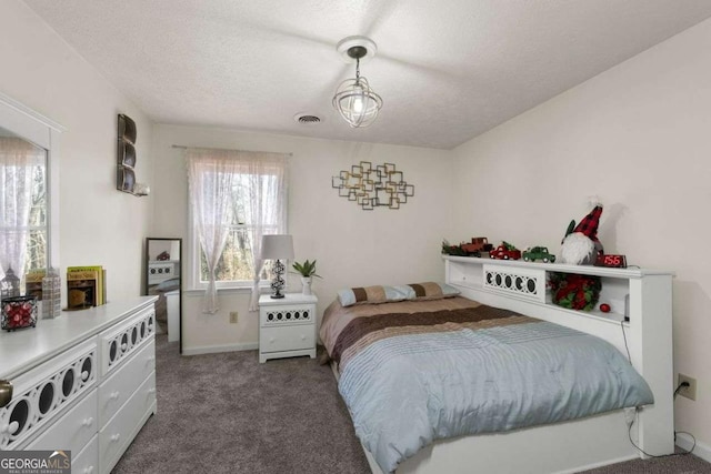 bedroom featuring a textured ceiling, carpet, and visible vents