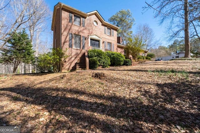 view of front facade with brick siding and fence