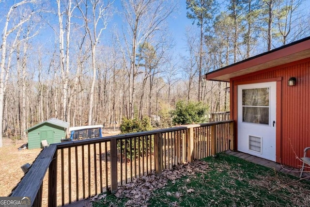 wooden deck featuring a storage unit and an outbuilding