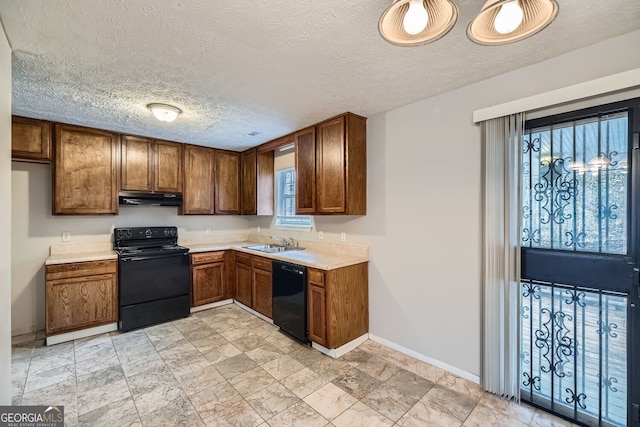 kitchen featuring light countertops, brown cabinetry, a sink, under cabinet range hood, and black appliances