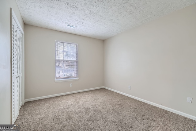 unfurnished bedroom featuring carpet floors, a closet, visible vents, and baseboards