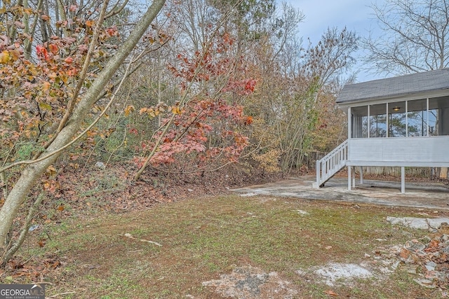 view of yard featuring a sunroom and stairway