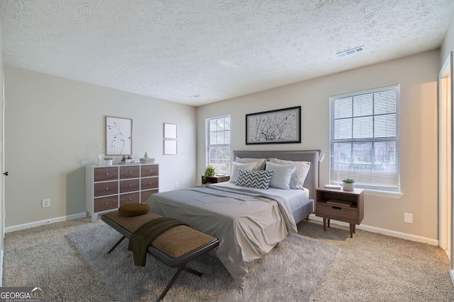 bedroom with carpet floors, visible vents, and baseboards