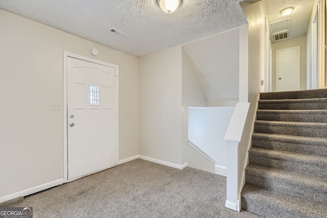 entrance foyer with carpet floors, baseboards, and visible vents