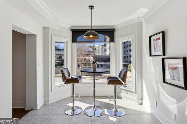 tiled dining area featuring ornamental molding and baseboards