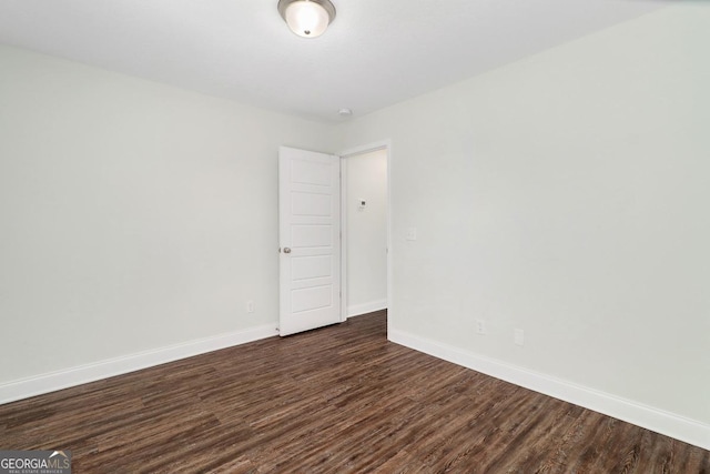 empty room with baseboards and dark wood-style flooring