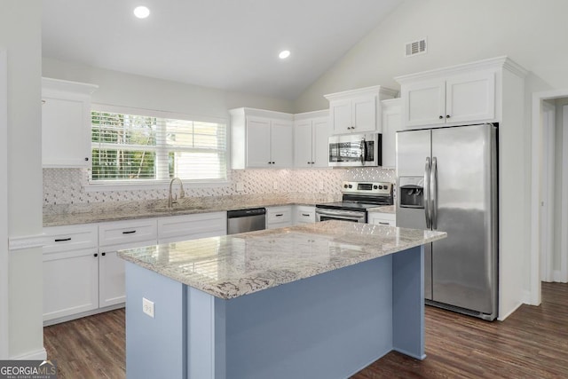 kitchen featuring dark wood finished floors, stainless steel appliances, lofted ceiling, visible vents, and white cabinetry