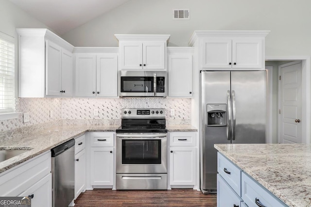 kitchen with lofted ceiling, stainless steel appliances, visible vents, and white cabinets