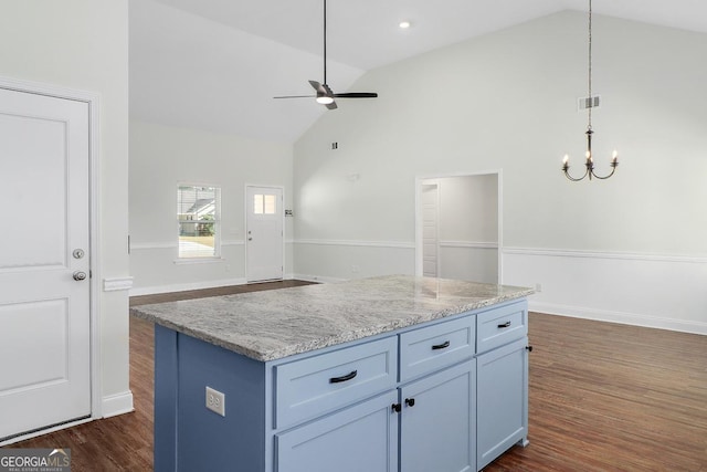 kitchen with light stone counters, open floor plan, decorative light fixtures, and dark wood finished floors