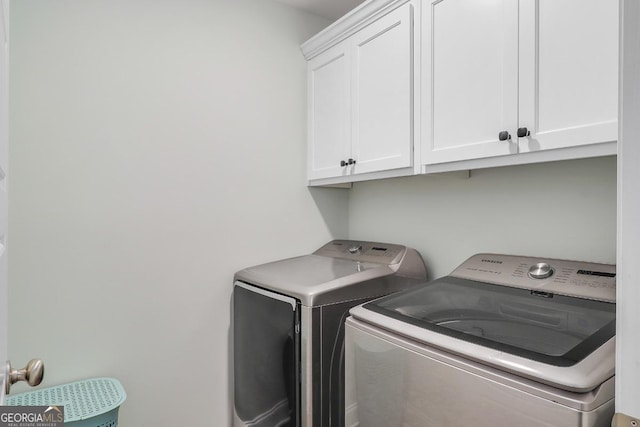 clothes washing area featuring cabinet space and washer and dryer