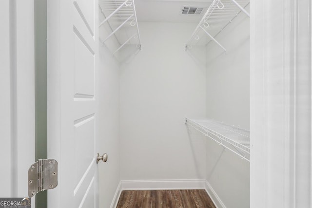 walk in closet featuring dark wood-style floors and visible vents